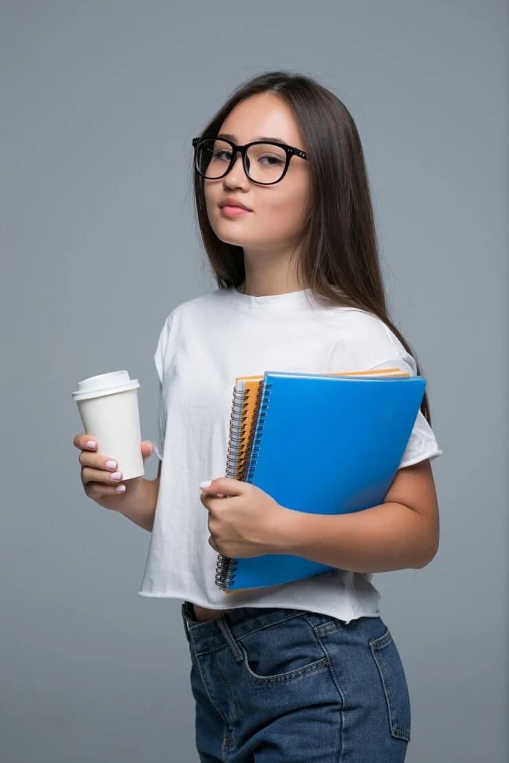 Instructor holding books and a coffee cup